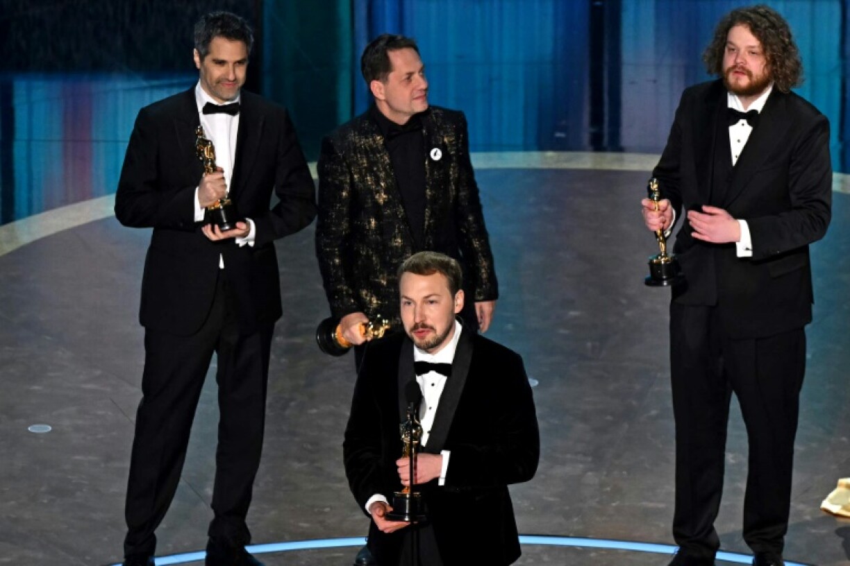 Latvian filmmaker Gints Zilbalodis (C), flanked by (L/R) French producer Gregory Zalcman, French producer Ron Dyens and Latvian animator and director Matiss Kaza, accept the award for Best Animated Feature Film for 'Flow'