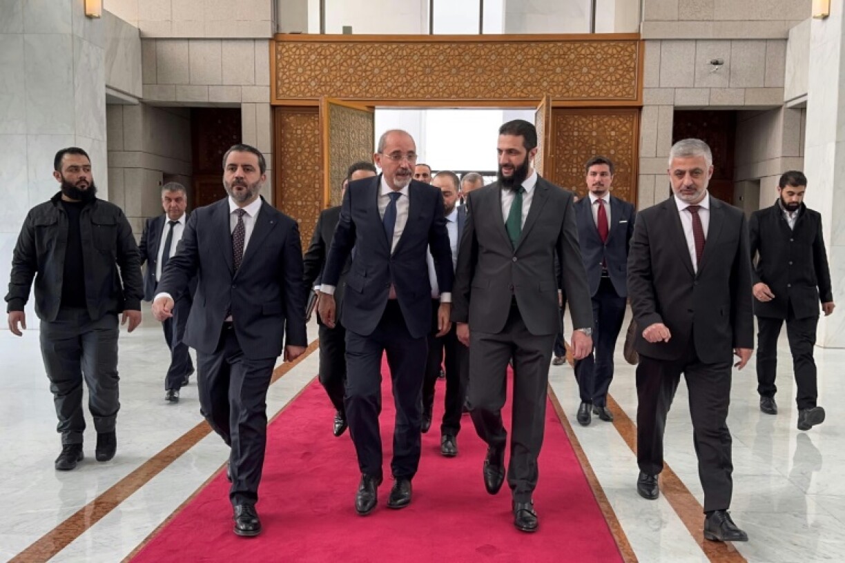 Jordanian Foreign Minister Ayman Safadi (C-L) is received by new Syrian leader Ahmed al-Sharaa (C-R) in Damascus