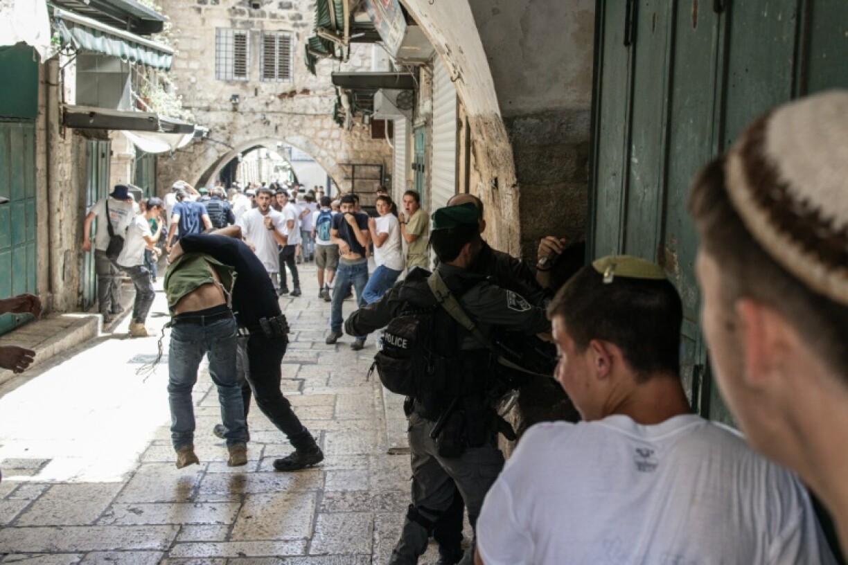 Police break up an attack on a Palestinian man by Israeli marchers during celebrations for Jerusalem Day on Monday