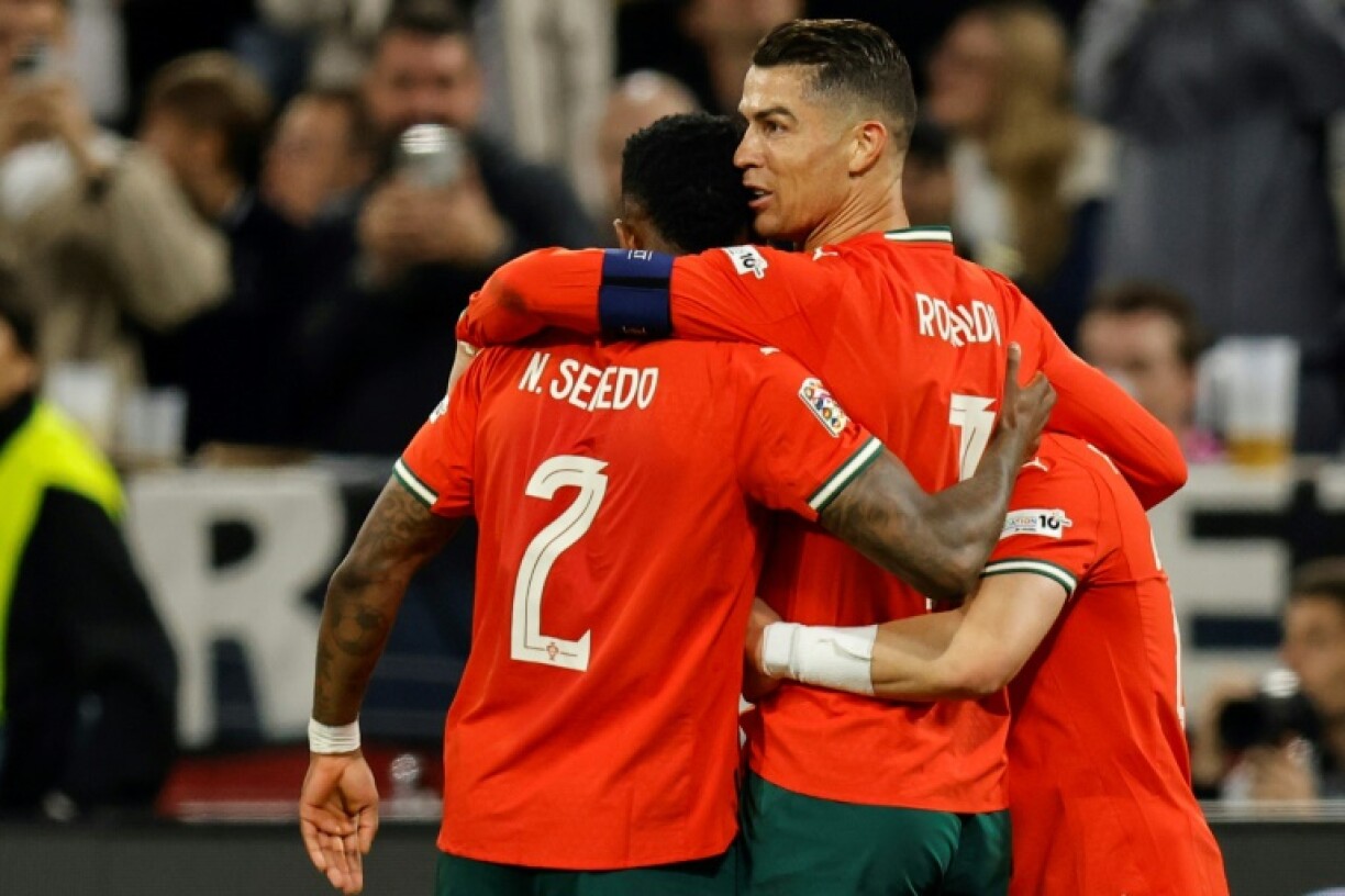 Cristiano Ronaldo (2nd R) is swamped by his teammates after scoring the winner for Portugal in their 2-1 Nations League semi-final victory over Germany