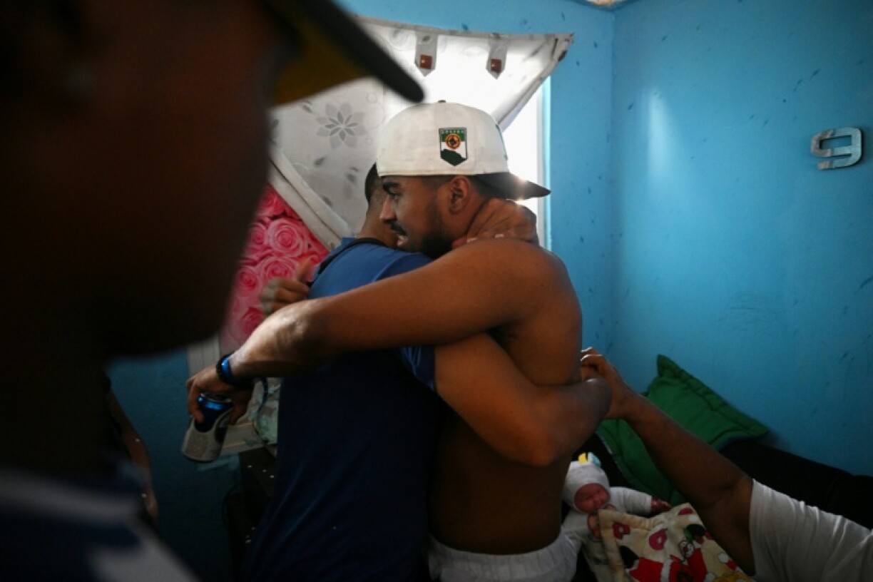 Edwuar Hernandez (R), a Venezuelan migrant repatriated from a prison in El Salvador, is welcomed by his family upon arrival at his home in Maracaibo, Venezuela