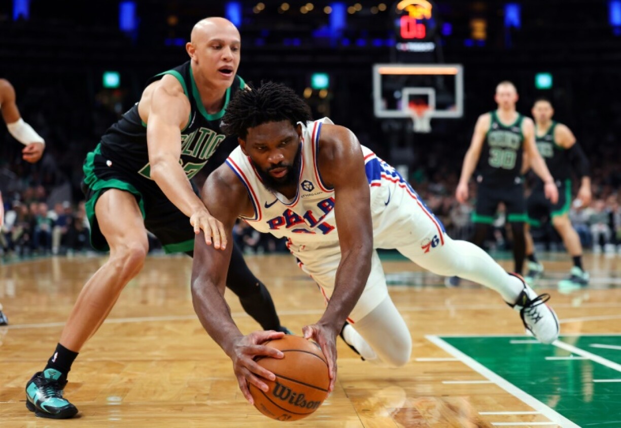 Joel Embiid plonge pour récupérer le ballon devant Jordan Walsh, lors de la victoire des Sixers, le 28 avril 2026 à Boston