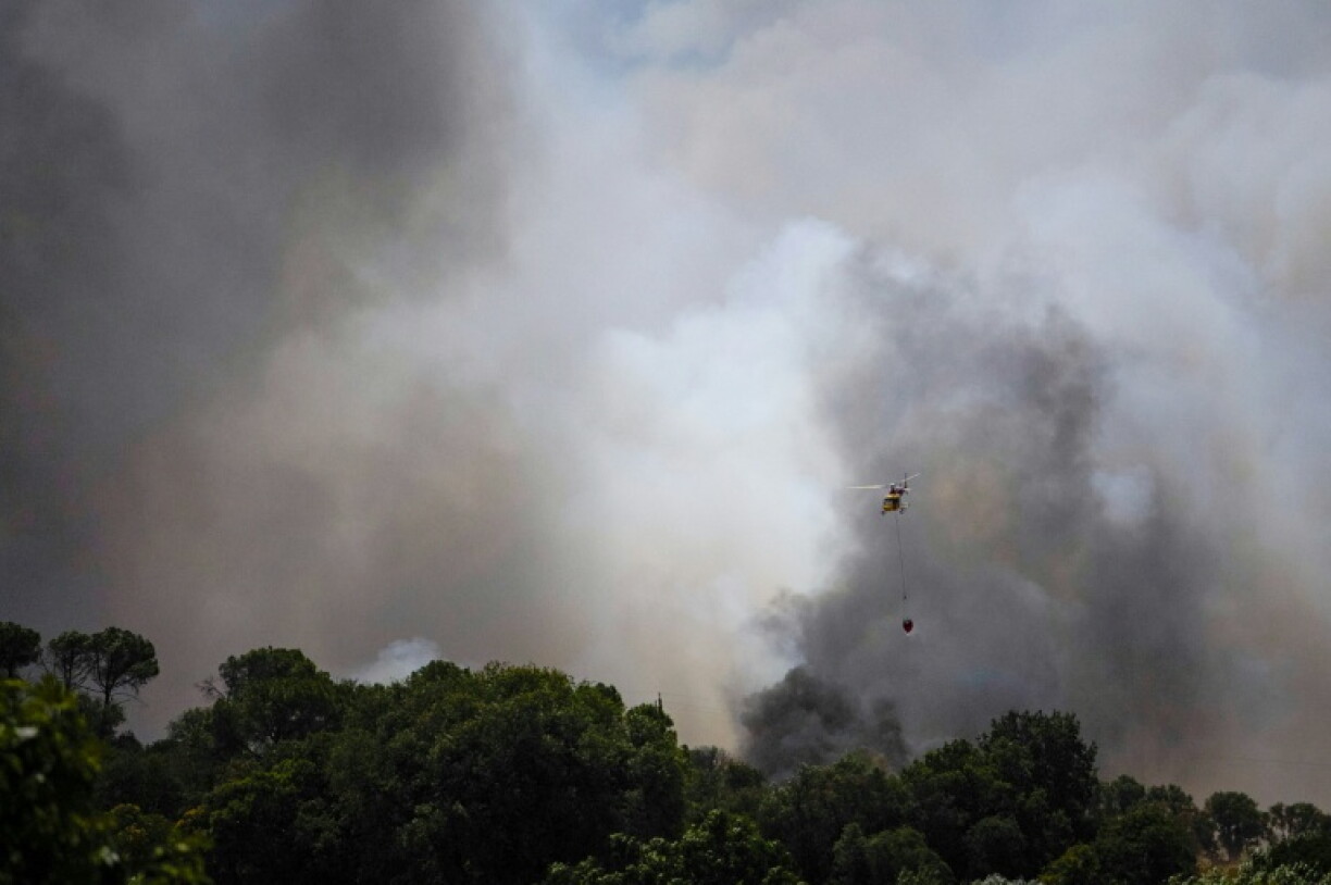 Un hélicoptère survole le 3 juillet 2026 un feu de forêt faisant rage près de La Bisbal de l'Empordà, dans le nord-est de l'Espagne, depuis contrôlé