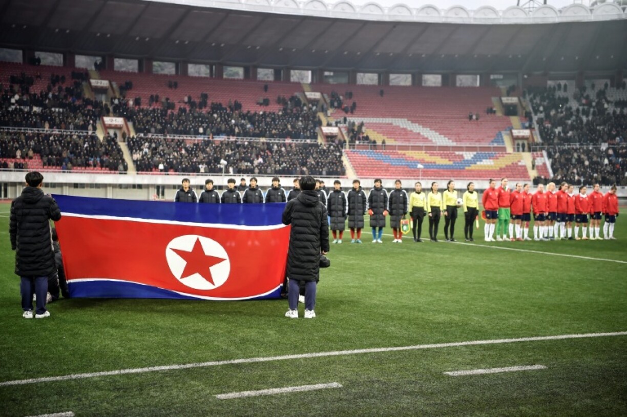 Le drapeau national nord-coréen est déployé avant un match amical de football opposant les équipes nationales féminines de Corée du Nord et de Russie au stade Kim Il Sung de Pyongyang, le 27 novembre 2025. La Corée du Nord a remporté le match sur le score de 5-2.