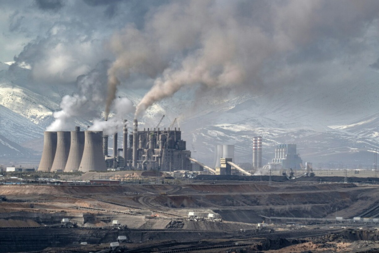 Mining vehicles extract coal from a lignite coal mine, as the Elbistan thermal power plant, is seen in the background in Elbistan on February 11, 2026