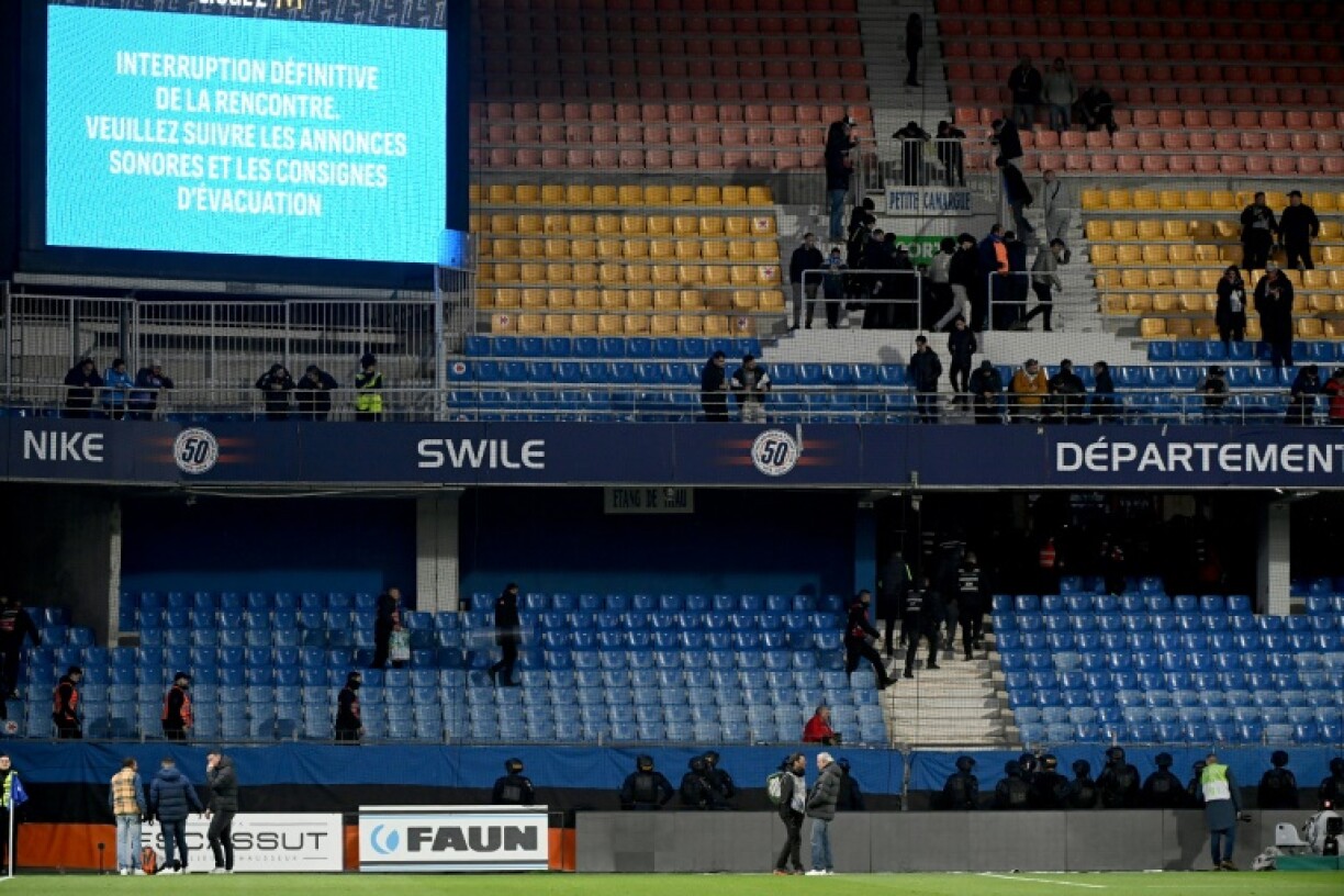 Riot police officers evacuate the stands after Sunday's Ligue 1 clash between Montpellier and Saint-Etienne was abandoned