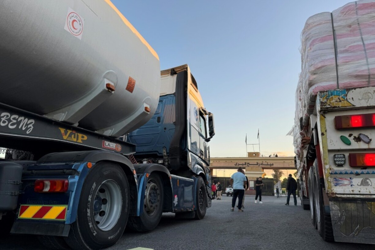 Trucks loaded with humanitarian aid on the Egyptian side of Rafah wait to cross the border