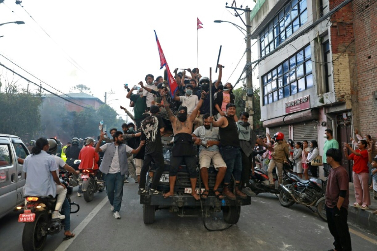 Demonstrators ride a police truck in Kathmandu, where protests reignited and spread to multiple cities nationwide