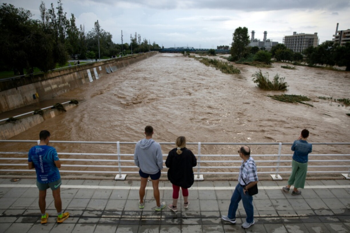 Des habitants regardent le fleuve Besòs, gonflé par des pluies torrentielles, le 4 octobre 2026 à Sant Adrià de Besòs, en périphérie de Barcelone