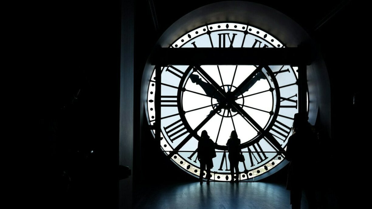 Women look over the Seine through at the Orsay Museum in Paris