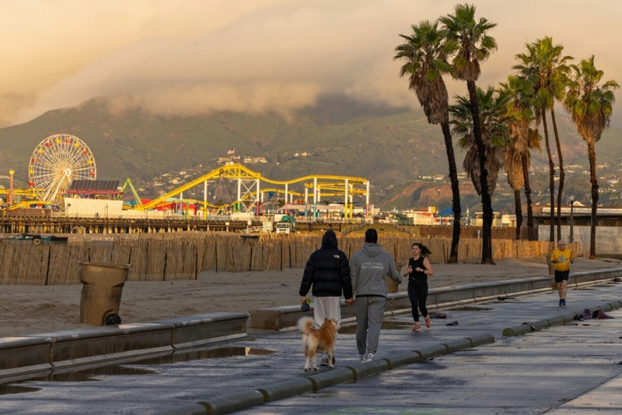 Des passants profitent d'une brève accalmie météo, le 25 décembre 2025 à Santa Monica, en Californie