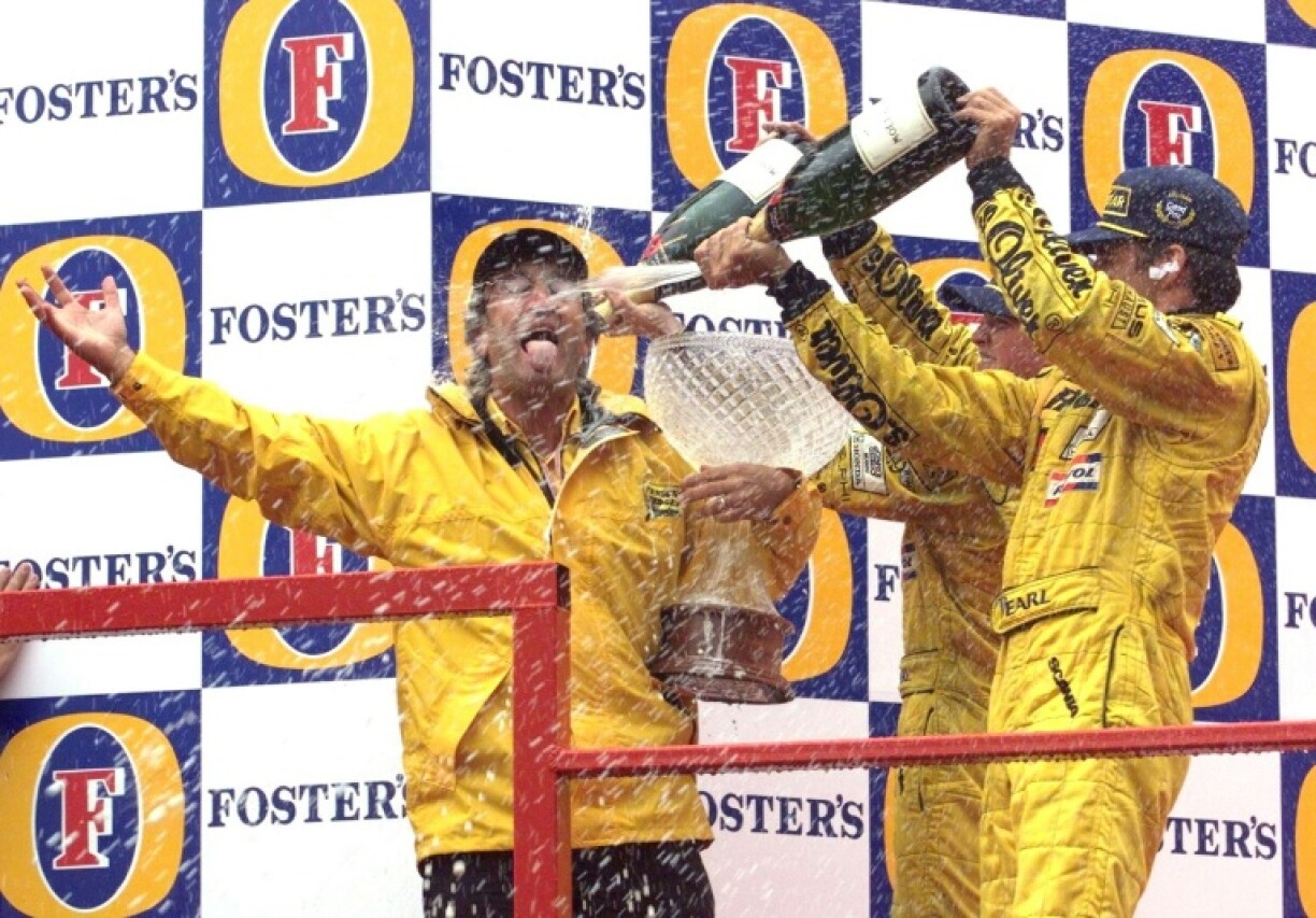 Damon Hill (R) and Ralf Schumacher spray champagne over Eddie Jordan after landing a remarkable one-two at the Belgium GP in 1998