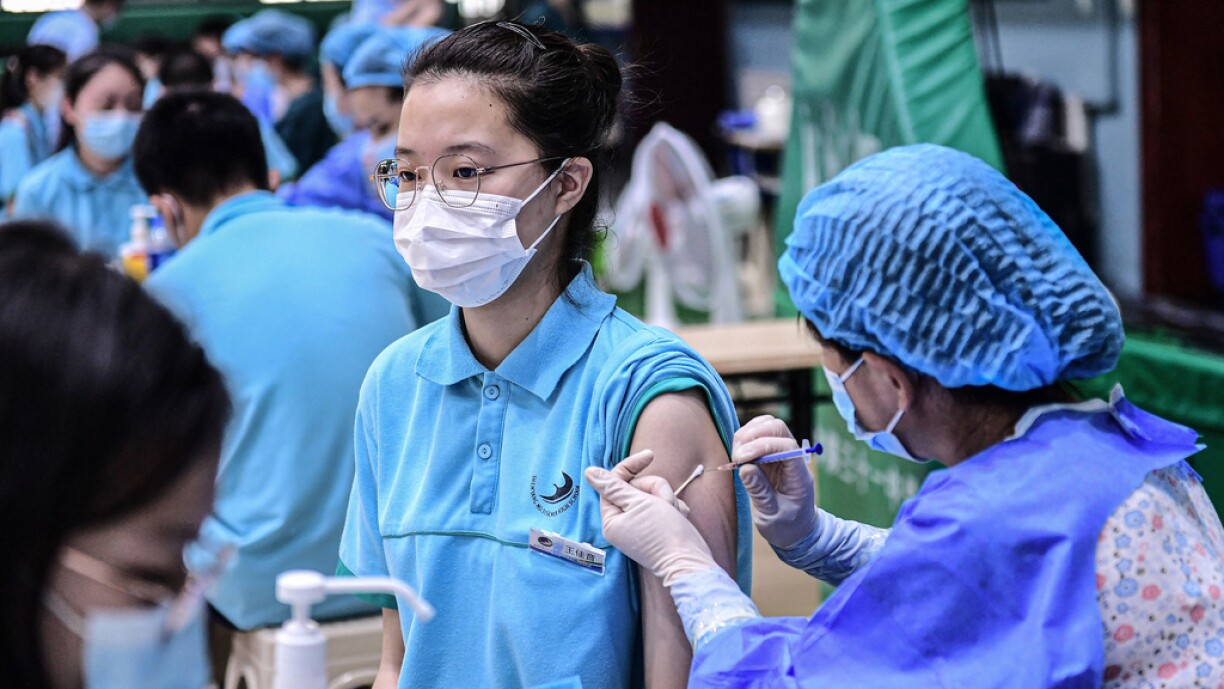 A student (L) receives the Sinopharm Covid-19 vaccine at a high school in Shenyang in China's northeastern Liaoning province on July 28, 2021.