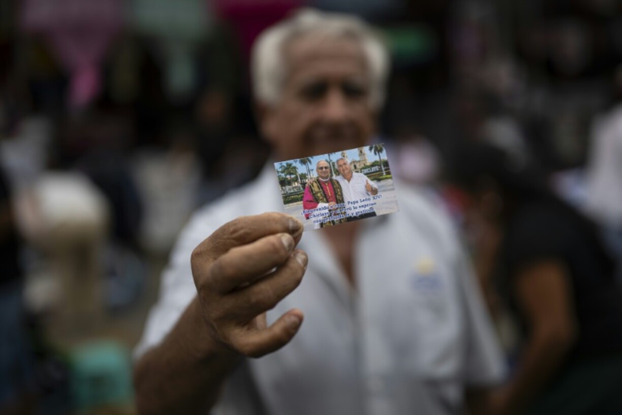 A resident of the Peruvian city of Chiclayo holds up a photo that he claims was taken with Pope Leo XIV before he became pontiff