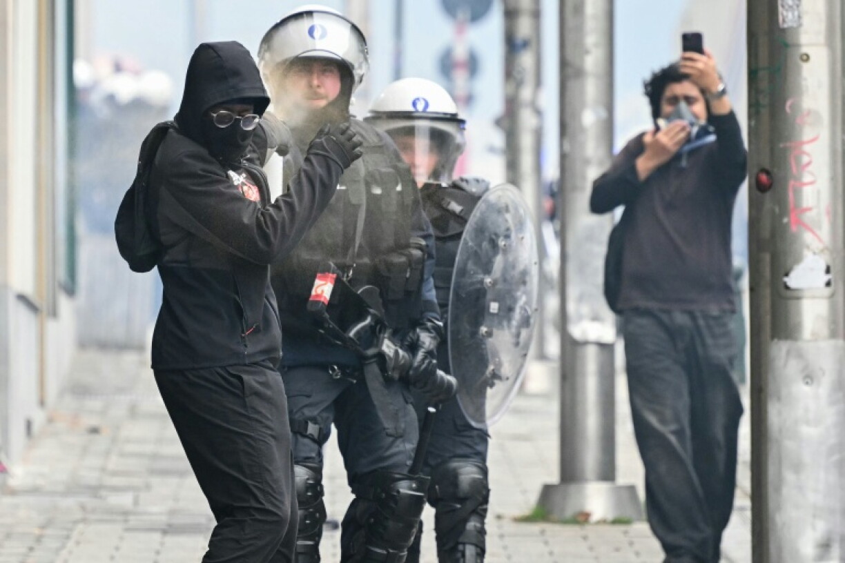 Un policier belge utilise une bombe de gaz sur un manifestant durant une manifestation syndicale à Bruxelles le 9 octobre 2026