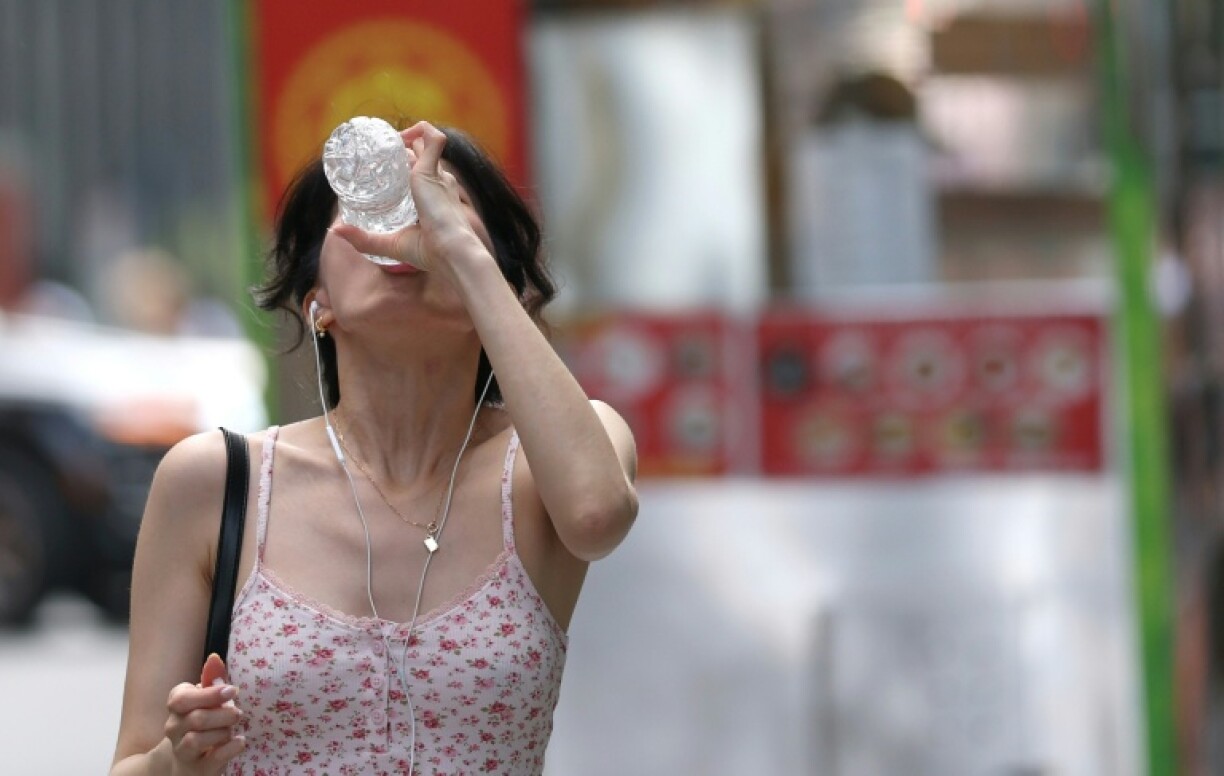 A woman drinks from a water bottle in New York City as an oppressive heat wave sends temperatures soaring across much of the eastern United States