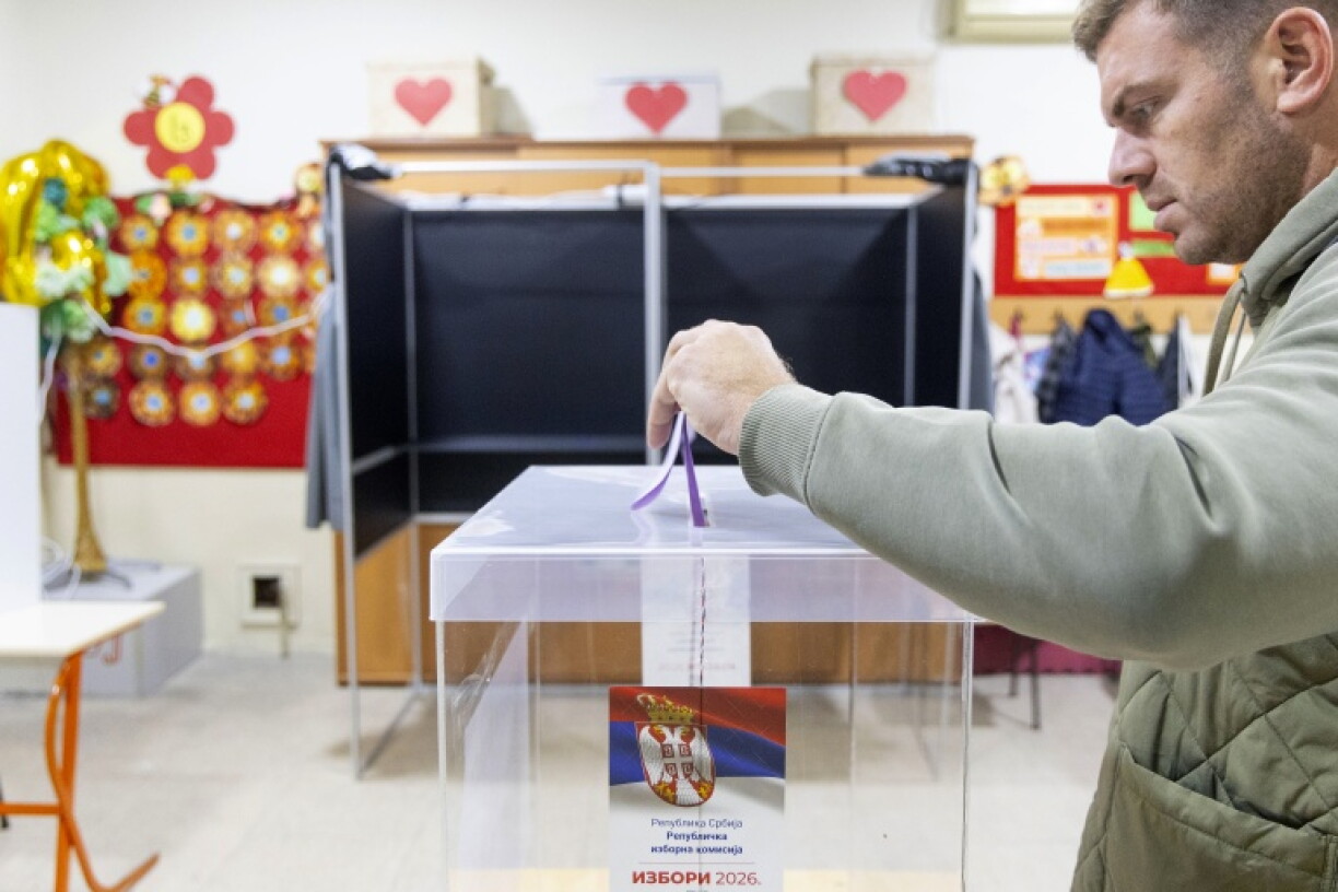 A voter casts a ballot at a polling station for Serbia's snap parliamentary elections