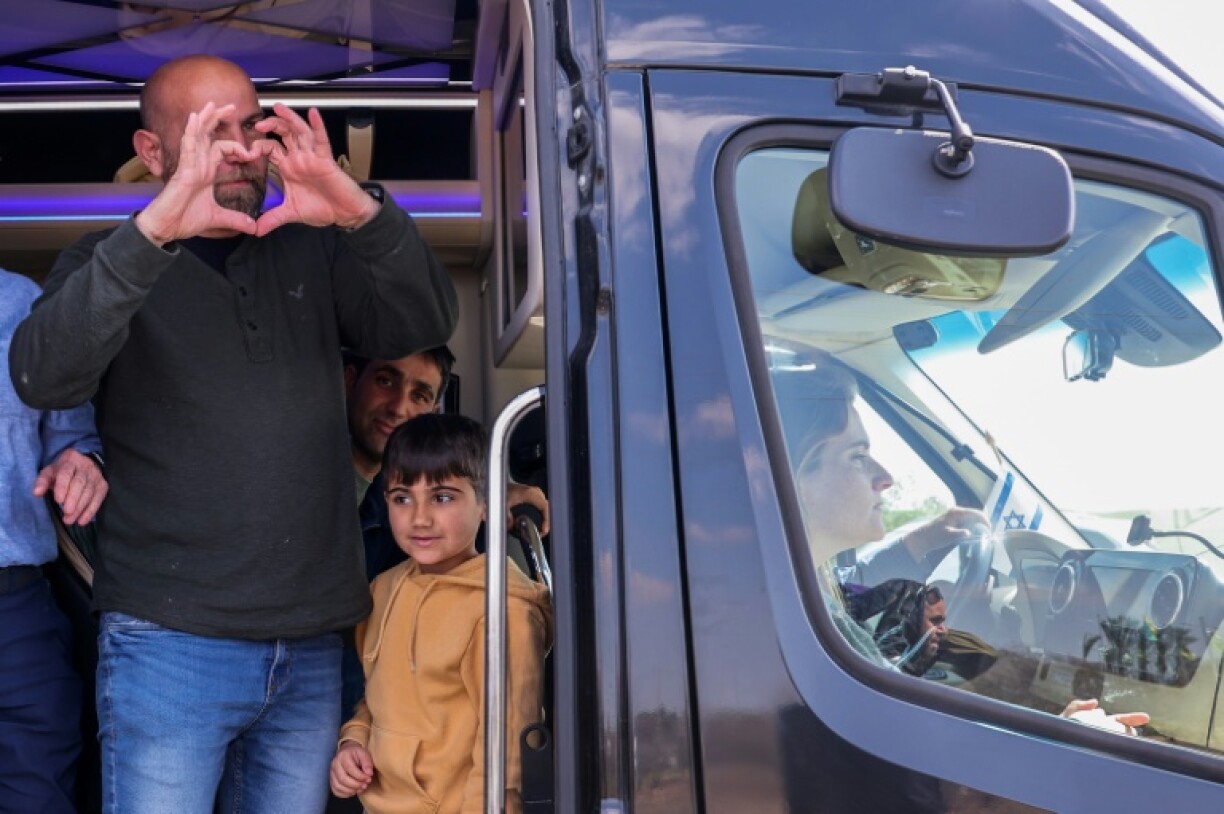 The sister of late Israeli hostage Shiri Bibas, Dana Silberman-Sitton, sits in the front as other family members greet mourners awaiting the Bibas' funeral convoy in kibbutz Nir Oz