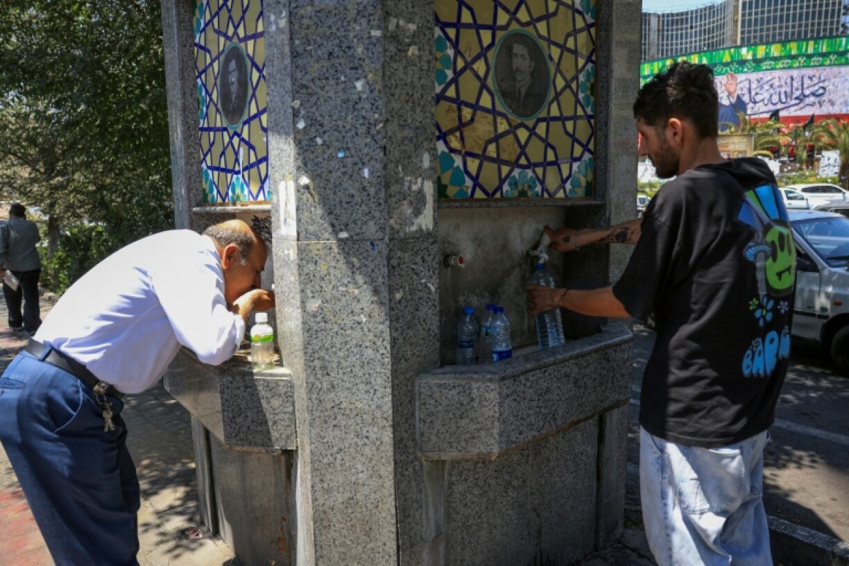 Tehran residents drink from a public fountain as temperatures in the Iranian capital soar.