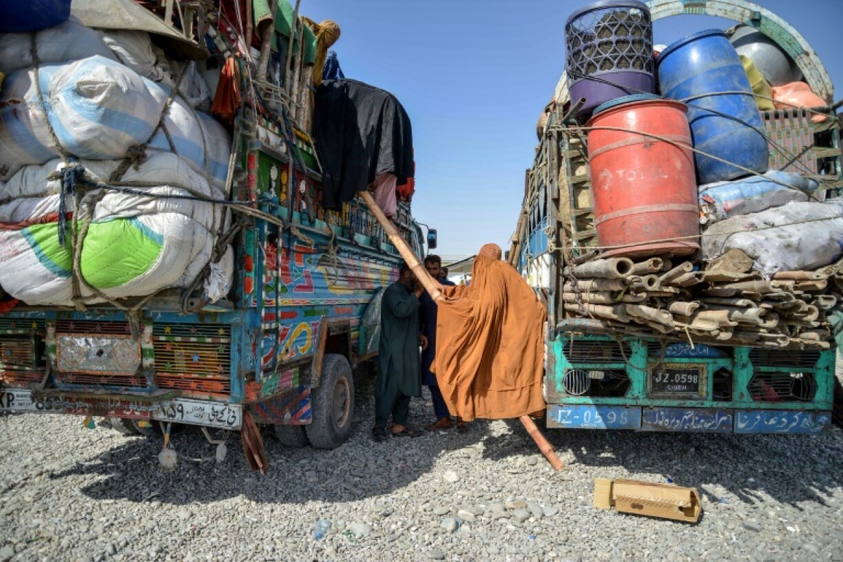 Afghan refugee women climb down from a truck upon their arrival from Pakistan at a registration centre in Takhta Pul district of Kandahar province on April 13, 2025