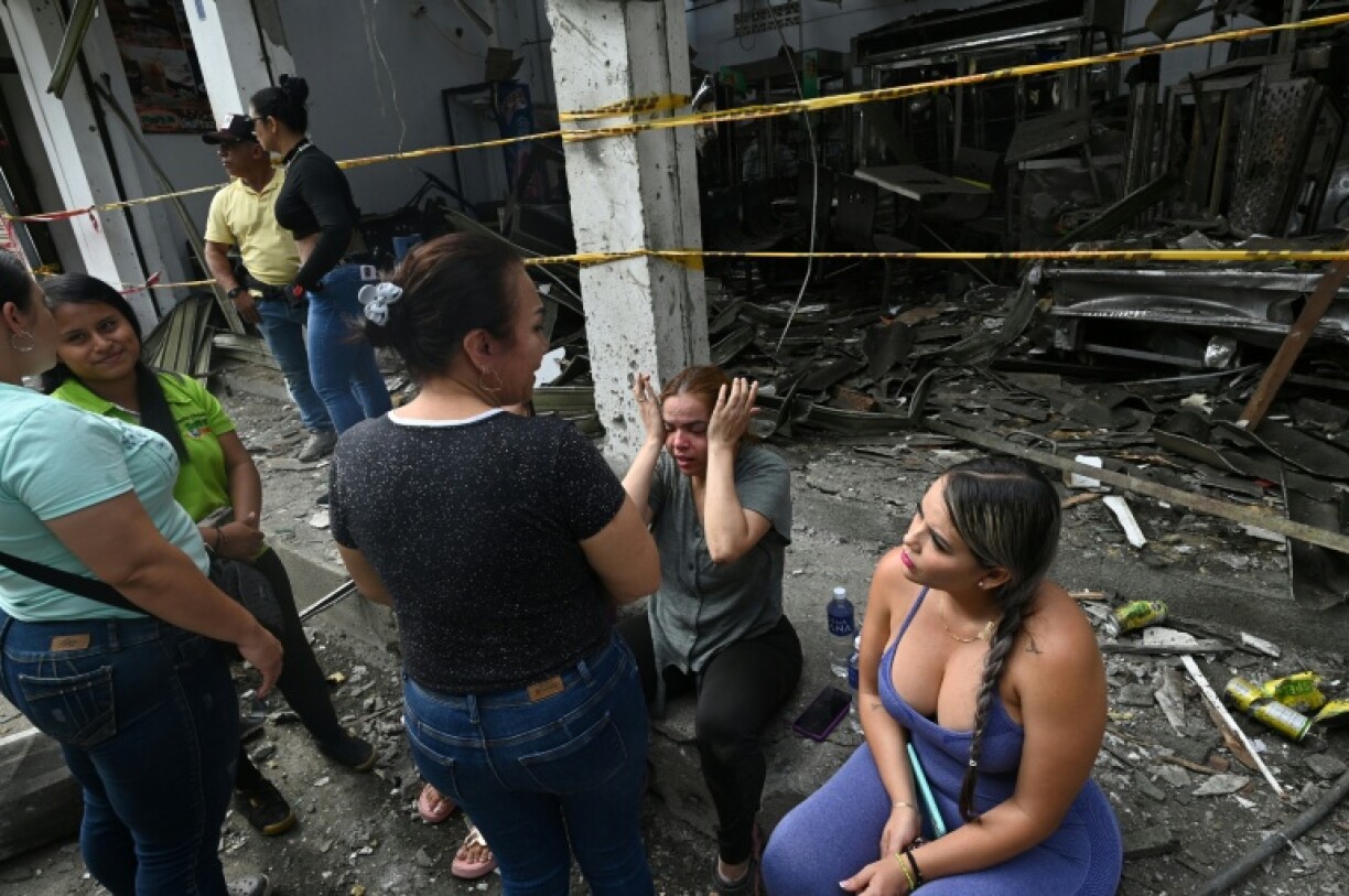 People gather in front of a destroyed building after a car exploded in front of the City Hall in Corinto, Cauca department, Colombia, on June 10, 2025.