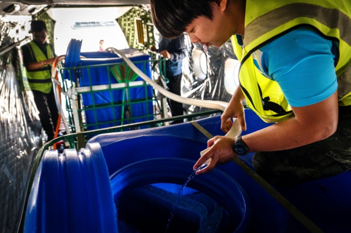 A worker with Thailand's Royal Rainmaking department adds water and ice to a container that will be emptied from about 1,500 metres