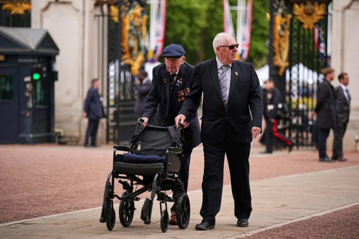A World War II veteran is escorted into Buckingham Palace