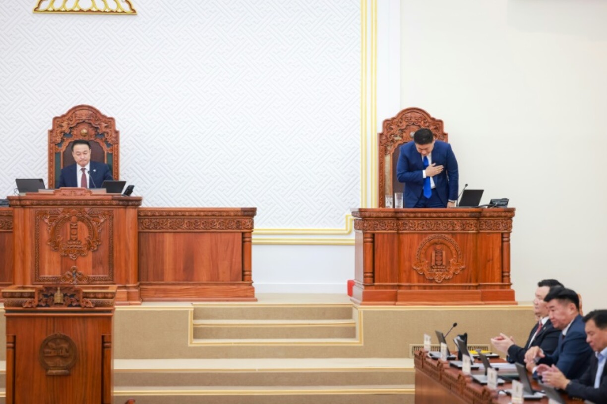 Prime Minister Luvsannamsrain Oyun-Erdene (R) bows after losing his position in a vote in Ulaanbaatar, capital city of Mongolia