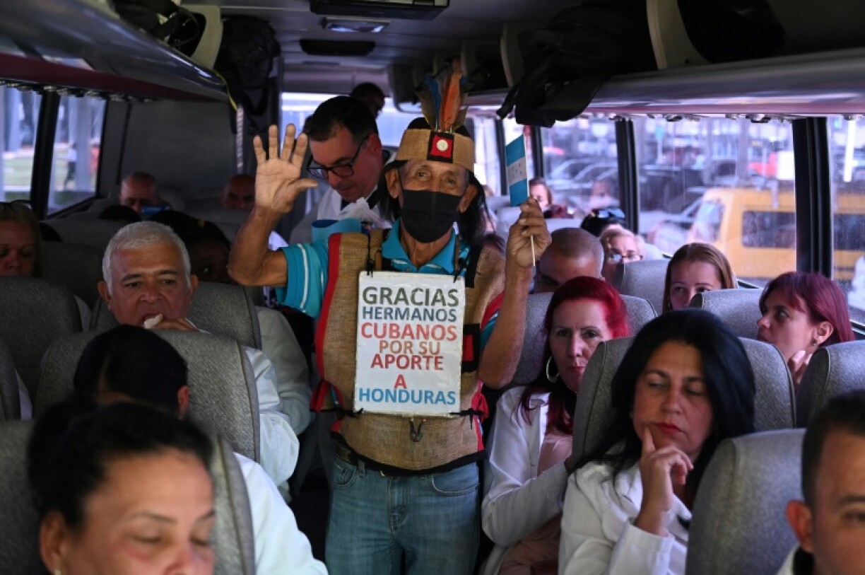 A man greets Cuban doctors on a bus after their arrival at Palmerola International Airport in Honduras in February 2024