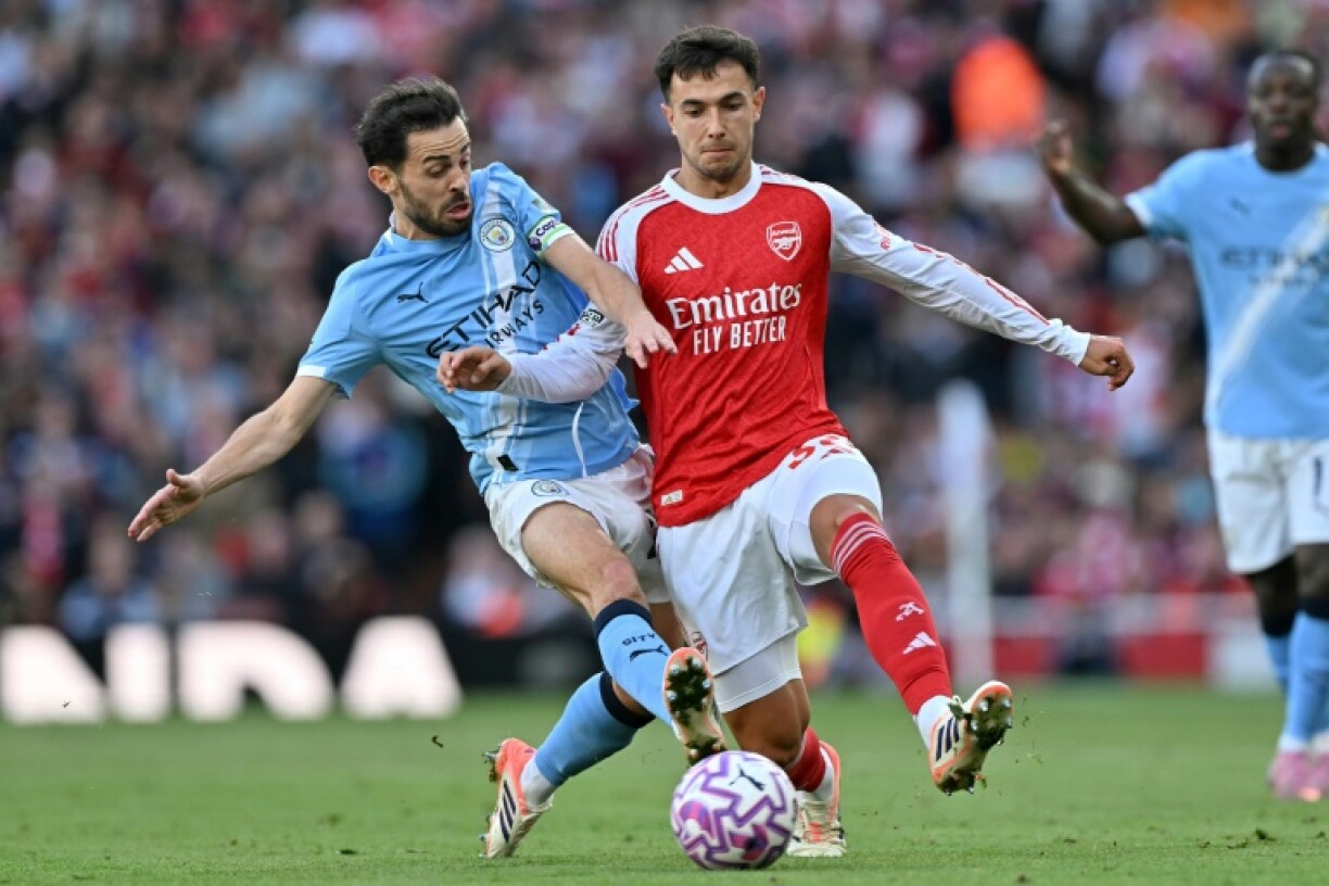 Manchester City's Bernardo Silva (L) in action against Arsenal