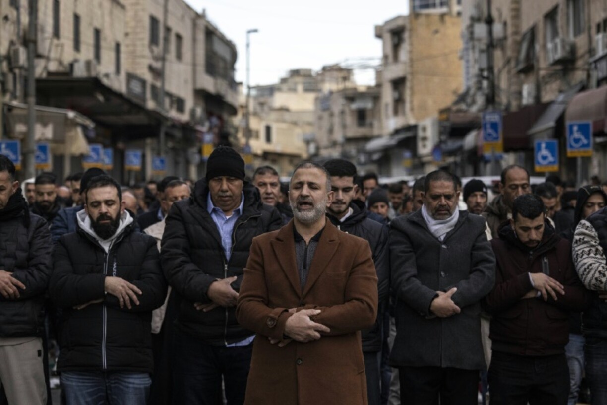 Des fidèles musulmans assistent à la prière matinale de l'Aïd el-Fitr dans la rue Salah al-Din, après que la police les a empêchés de s'approcher des remparts de la vieille ville de Jérusalem, le 20 mars 2026