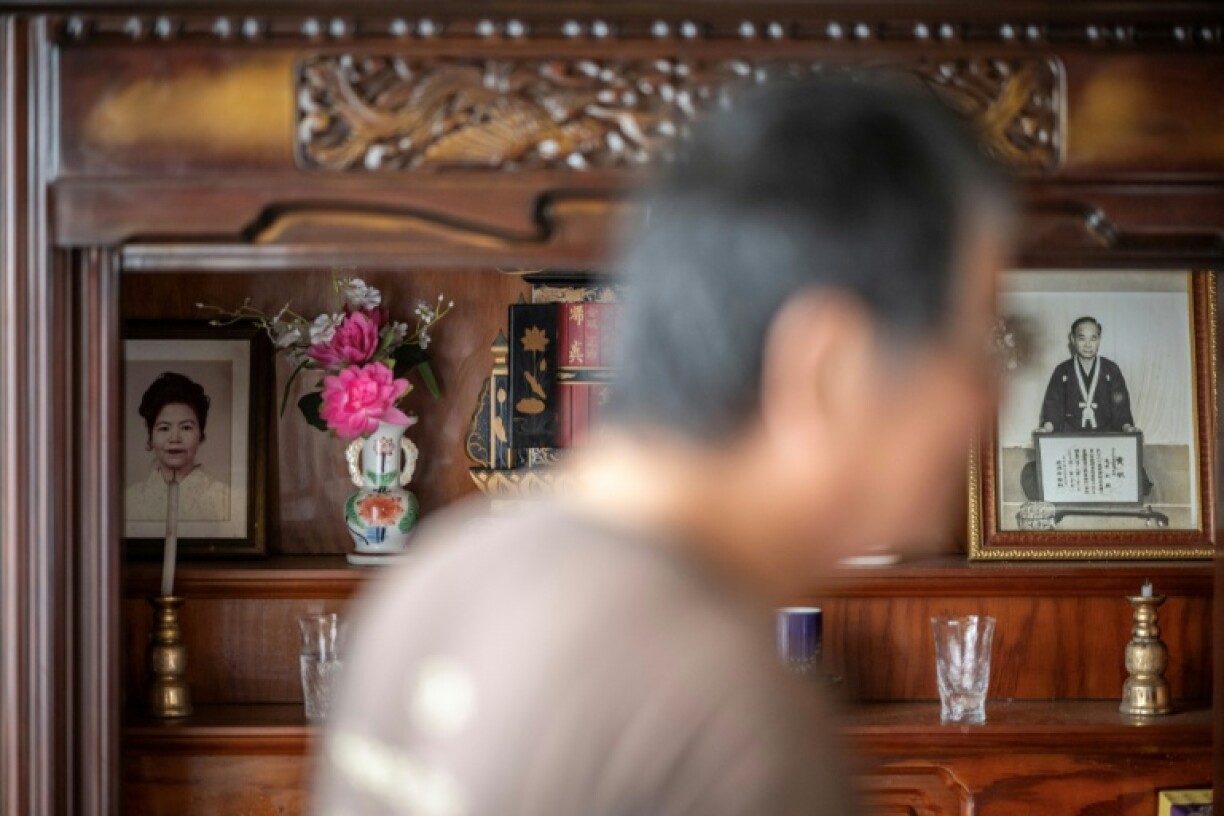 A portrait (L) of Takemasa Kinjo's mother, who was killed by a US Marine in 1974