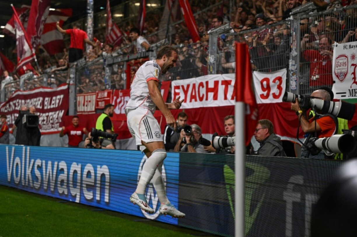 Bayern Munich striker Harry Kane celebrates with fans after scoring a stoppage-time winner in the first minute of the German Cup.
