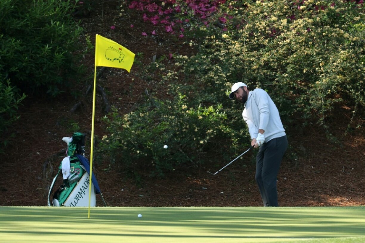 Defending champion Scottie Scheffler of the United States chips on the 12th hole during a practice round before the 2025 Masters at Augusta National