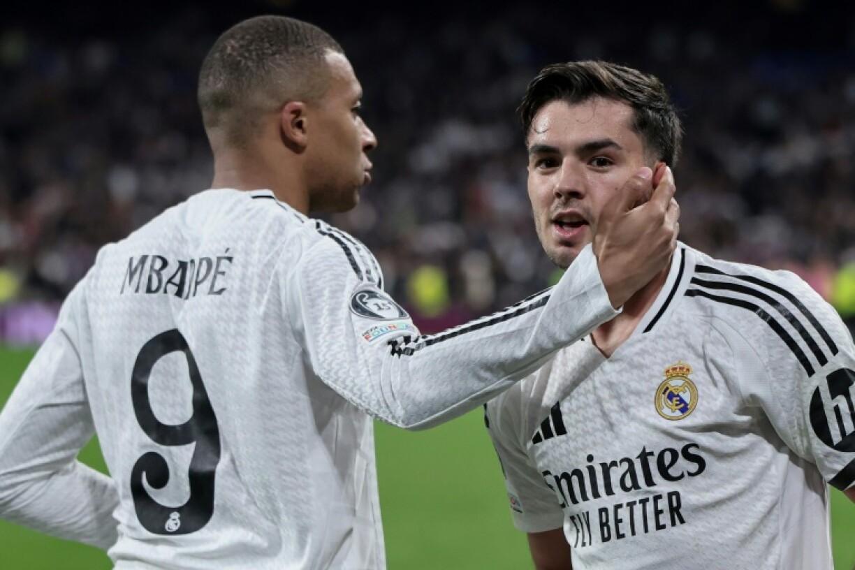Real Madrid's Moroccan playmaker Brahim Diaz (R) celebrates scoring his team's second goal against Atletico Madrid