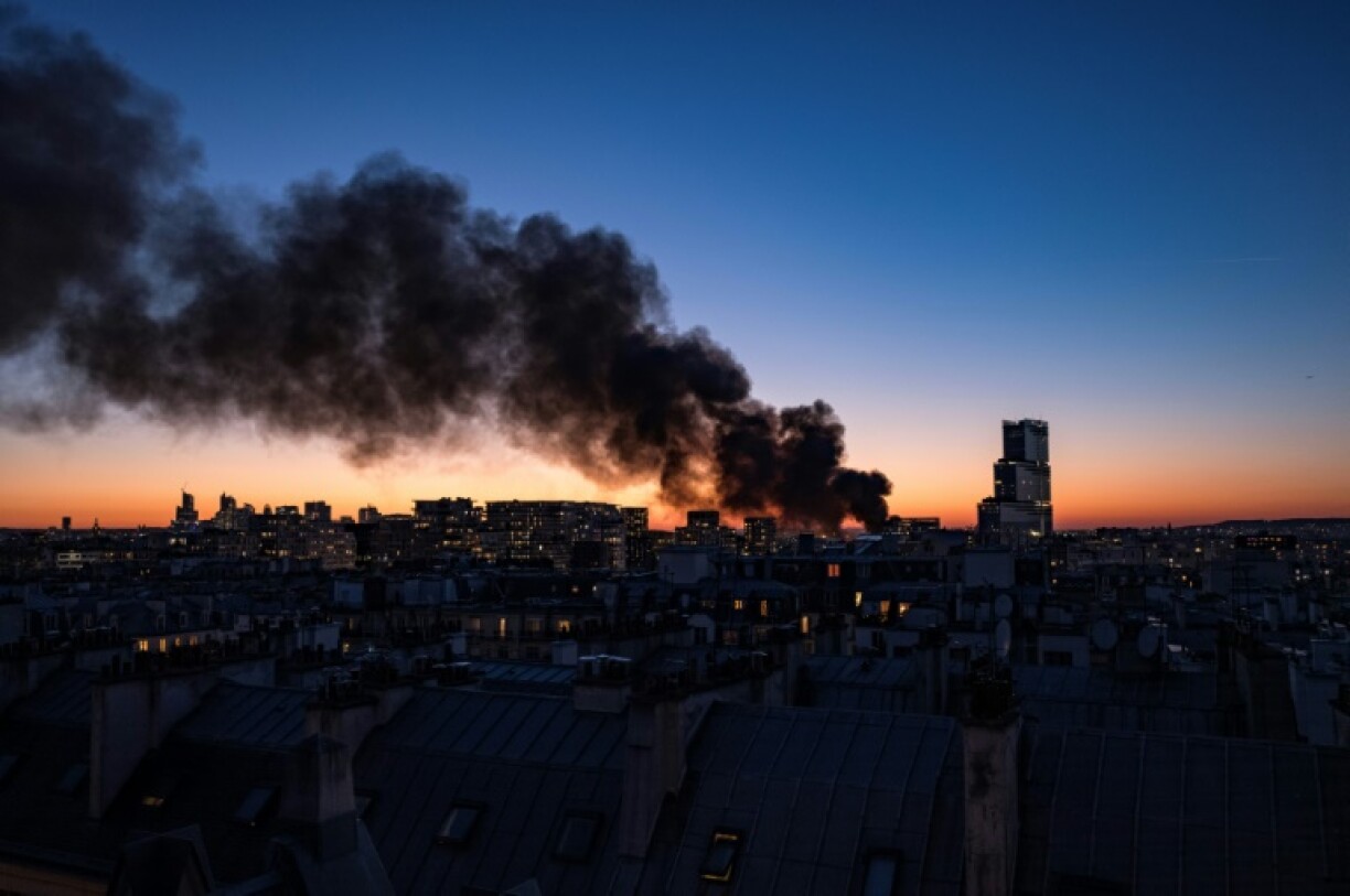 Smoke billows across the Paris skyline from an inferno next to a new glass skyscraper designed by Italian architect Renzo Piano