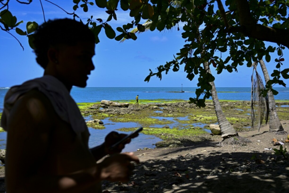A Venezuelan migrant waits on the beach in Panama for a boat to Colombia