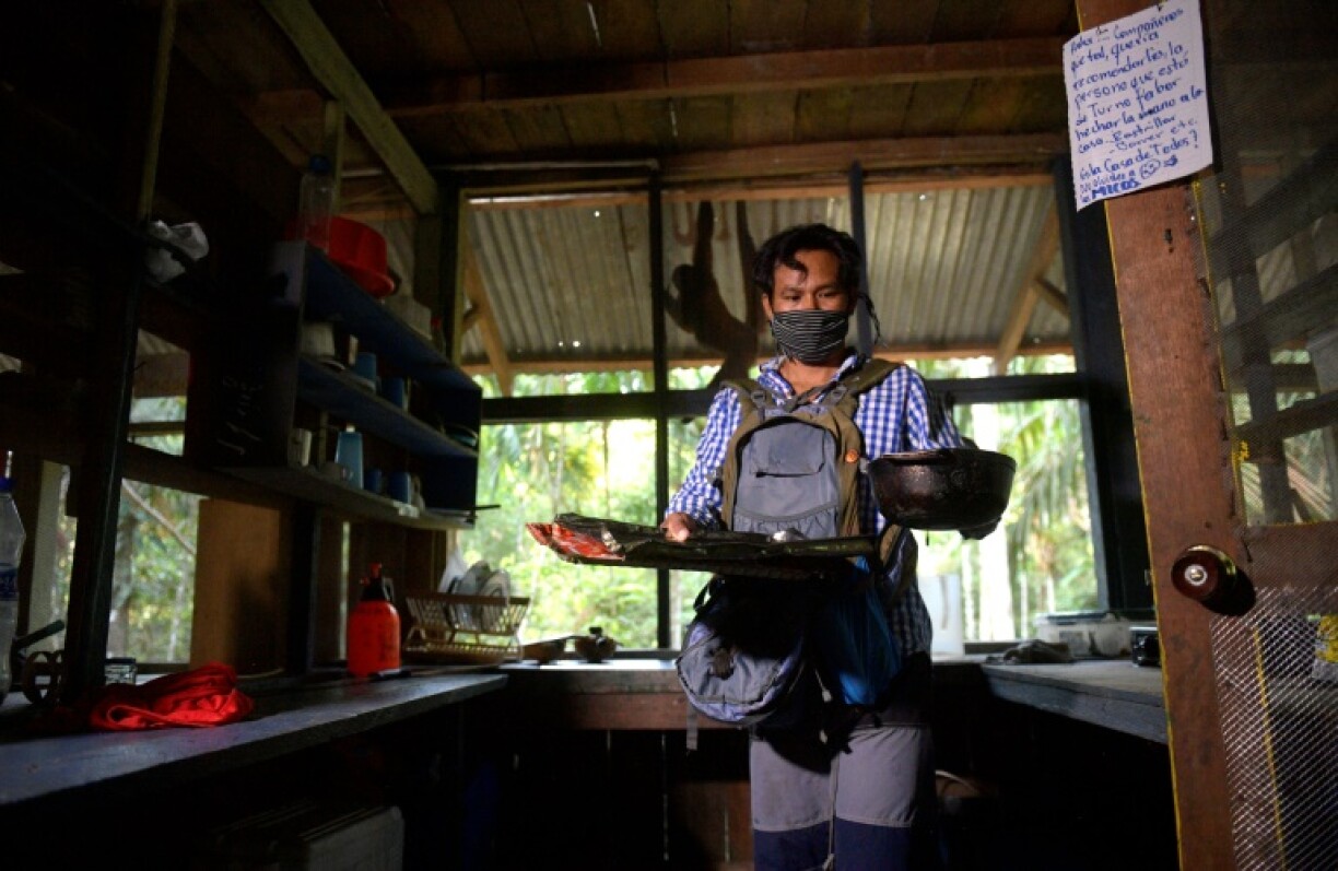 Jhon Jairo Vasquez, s'apprête à nourrir les singes lainaux du refuge de Maikuchiga, le 18 novembre 2020 près de Leticia, en Amazonie colombienne