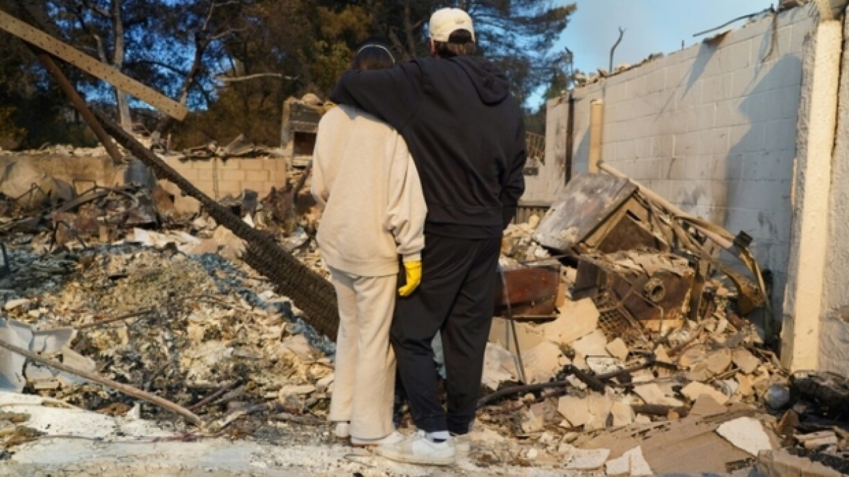 Kyle Kucharski et sa femme Nicole Perri contemplent les ruines de leur maison, dévastée par un incendie à Pacific Palisades, près de Los Angeles, le 10 janvier 2025