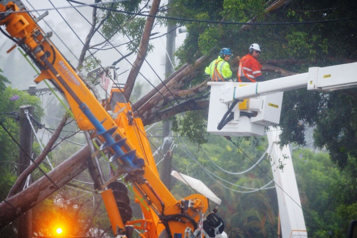 Energex utility crews clear a fallen tree following the passage of tropical cyclone Alfred in Brisbane