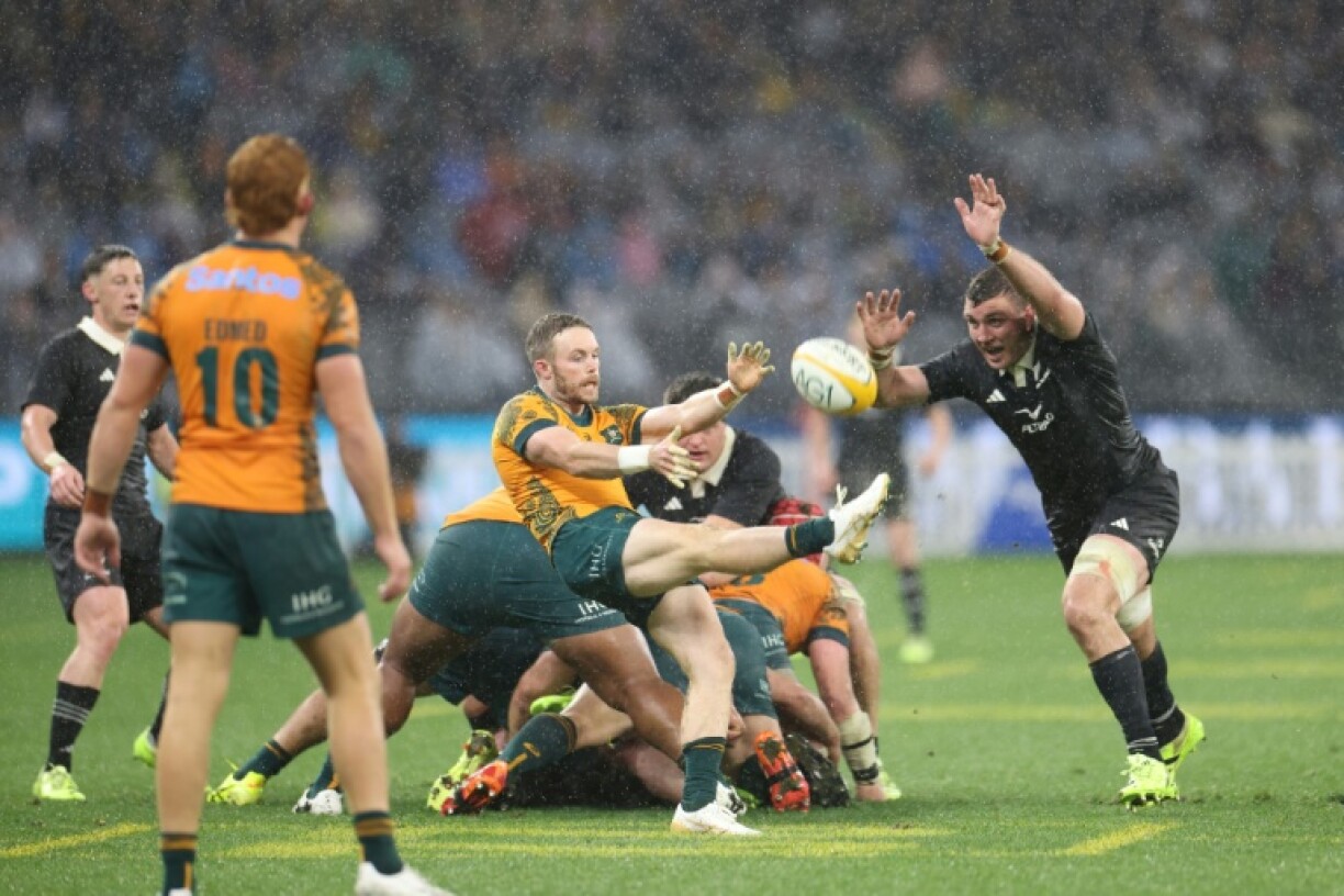 New Zealand defeated Australia 28-14 in wet conditions in Perth to keep their Rugby Championship title hopes alive
