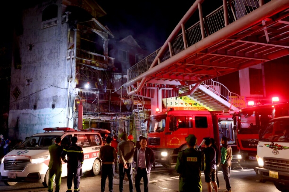 Firefighters extinguish a fire that killed 11 people at a karaoke bar in Hanoi