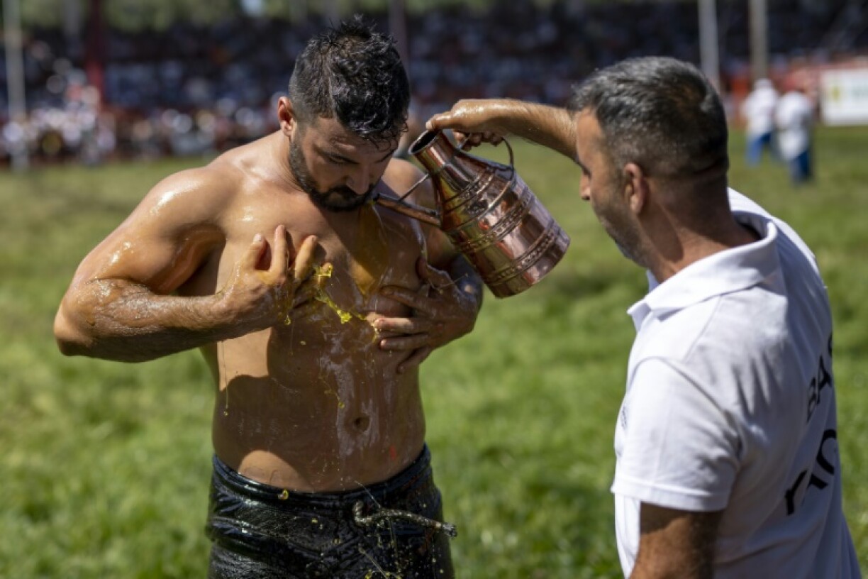 Un lutteurse fait huiler le corps lors du championnat annuel Kirkpinar à Edirne, dans le nord-ouest de la Turquie, le 6 juillet 2024