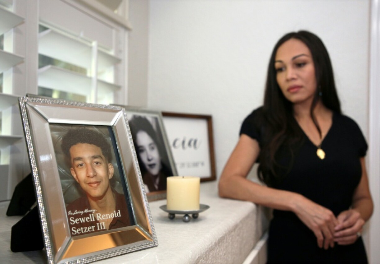 Megan Garcia stands next to a picture of her late son, Sewell Setzer III. The 14-year-old had fallen in love with a 'Game of Thrones' -inspired chatbot from Character.AI