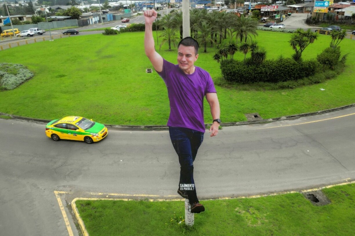A car drives past a giant image of Ecuador's President Daniel Noboa on a roundabout in Quito