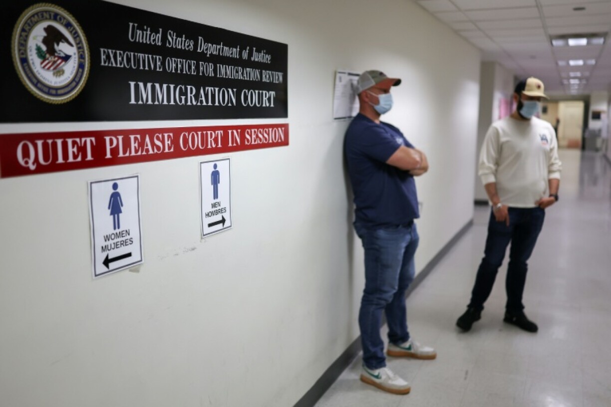Plainclothes federal agents with US Immigration and Customs Enforcement wait in a hallway outside of an immigration courtroom in New York City