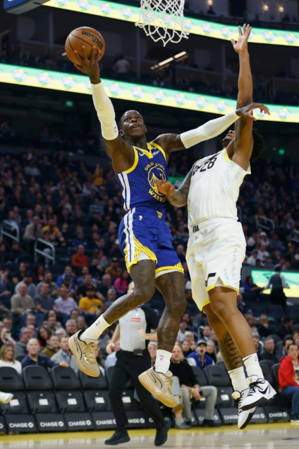 Dennis Schroder of the Golden State Warriors goes to the basket against Brice Sensabaugh in the Warriors' NBA victory over the Utah Jazz