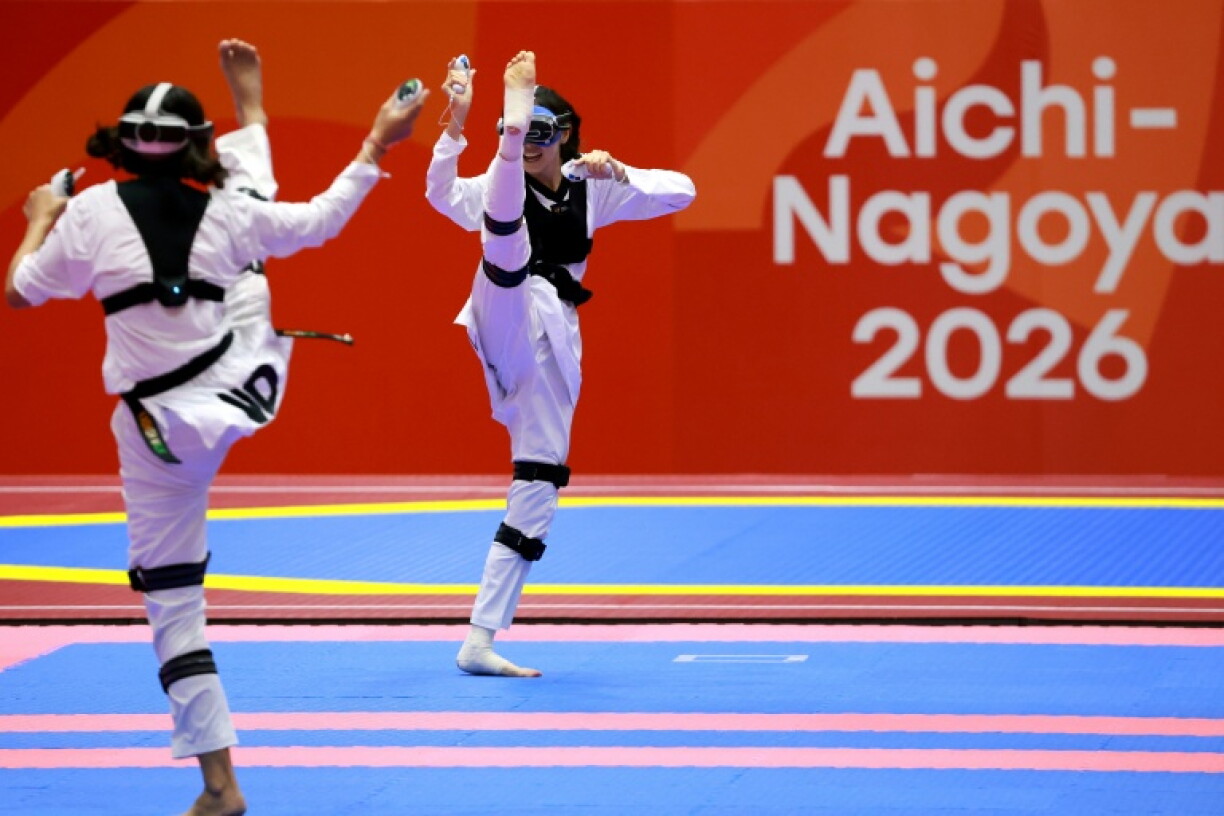 Kazakhstan's Rita Bakisheva (R) competes against India's Kashish Malik in the mixed individual virtual taekwondo
