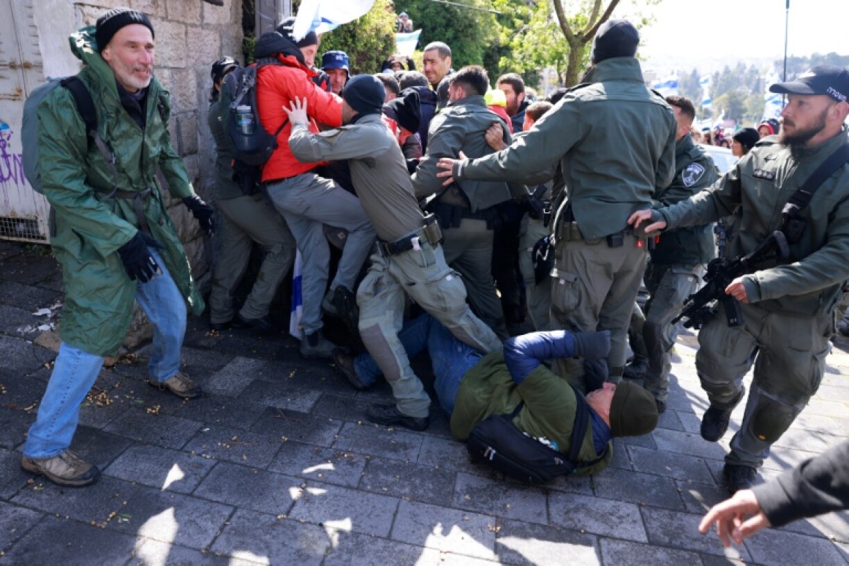 Israeli protesters and police scuffle in front of the prime minister's residence in Jerusalem during a demonstration calling for an end to the war in Gaza and to bring home all hostages held there by militants