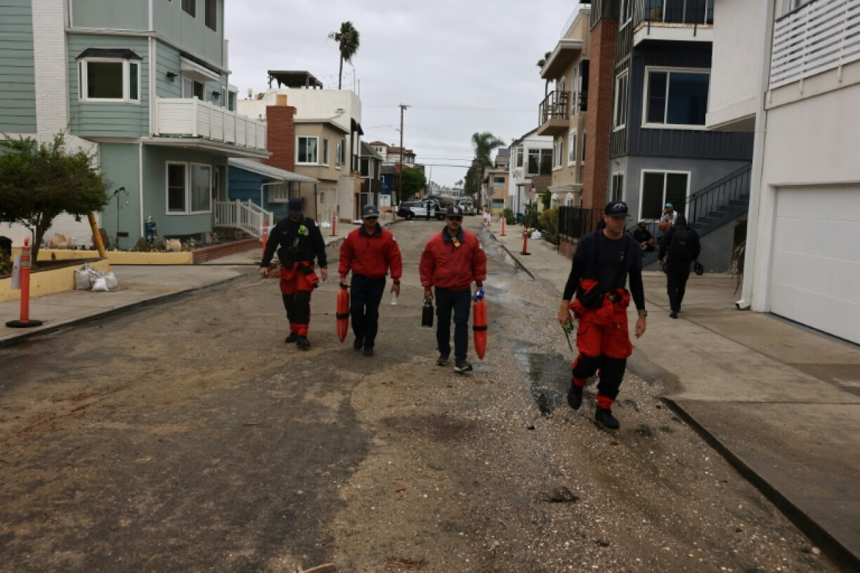 Members of the fire department inspect storm damage on the boardwalk and homes created by Tropical Storm Rachel in Long Beach, California